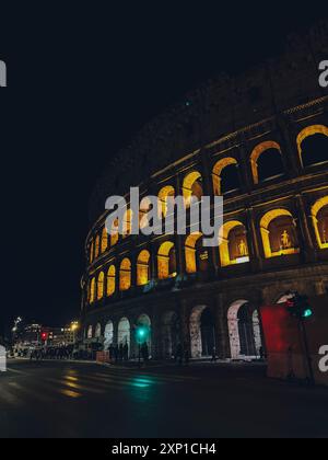 Ein großes Gebäude mit Bogenfenstern wird nachts beleuchtet Stockfoto
