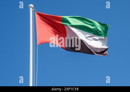 Die Flagge der Vereinigten Arabischen Emirate winkt stolz gegen den Azure Sky Stockfoto