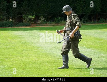 Mann, der in deutscher Uniform des Zweiten Weltkriegs läuft. Schmeisser Maschinenpistole Stockfoto