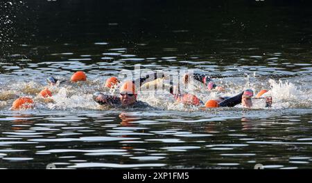 Triathlon-Wettkämpfer für Damen warten am Anfang des Schwimmens. Stockfoto