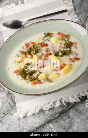 Wurst und Grünkohl Zuppa toscana italienische cremige Suppe Nahaufnahme auf dem Teller auf dem Tisch. Vertikal Stockfoto