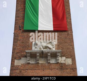 Vicenza, VI, Italien - 10. Mai 2024: Geflügelter Löwe und riesige italienische Flagge auf dem alten Turm Stockfoto