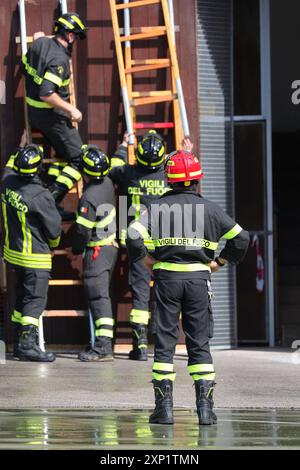 Vicenza, VI, Italien - 23. Mai 2024: Feuerwehrchef koordiniert die Feuerwehrleute, die Leiter für den Aufstieg in das Gebäude montieren Stockfoto