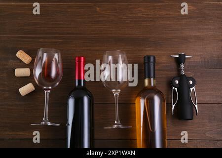 Flache Lagenkomposition mit Flügelkorkenzieher und Wein auf Holztisch Stockfoto