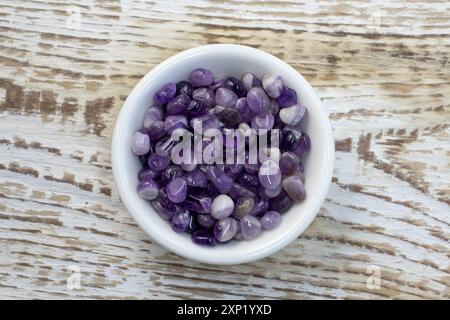 Set aus verschiedenen natürlichen Amethyst-Mineralsteinen und Edelsteinen auf grauem hölzernem Hintergrund, teilweise fokussiert von oben Stockfoto