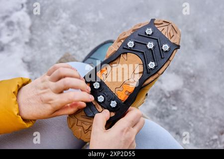 Gummipolster mit Stacheln an der Sohle von Wanderschuhen zum Schutz vor Verrutschen auf eisigem Schnee. Stockfoto