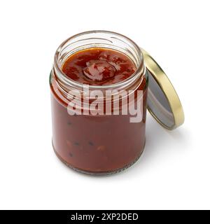 Glasgefäß mit Tomatenzwiebelchutney und nigella-Samen nah oben isoliert auf weißem Hintergrund Stockfoto