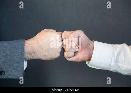 Nahaufnahme von zwei nicht erkennbaren Geschäftsmännern, die sich gegenseitig mit Faustschlag begrüßen. Stockfoto