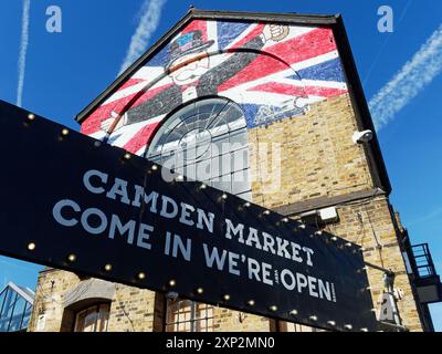 Blick auf das Schild über einen belebten Eingang zum Camden Market an der Chalk Farm Road in London an einem sonnigen Tag Stockfoto