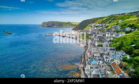 Das schottische Dorf Gardenstown Aberdeenshire beherbergt die Hafenmauern und das blaue Meer bei Flut Stockfoto