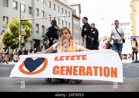 Augsburg, Deutschland. August 2024. Letzte Generation ungehorsame Versammlung am 3. August 2024 in Augsburg. Sie protestieren unter dem Motto " Öl tötet " wie die internationale Kampagne des A22-Netzes, das derzeit Flughäfen blockiert, die einen Vertrag über die Nichtverbreitung fossiler Brennstoffe fordern. (Foto: Alexander Pohl/SIPA USA) Credit: SIPA USA/Alamy Live News Stockfoto