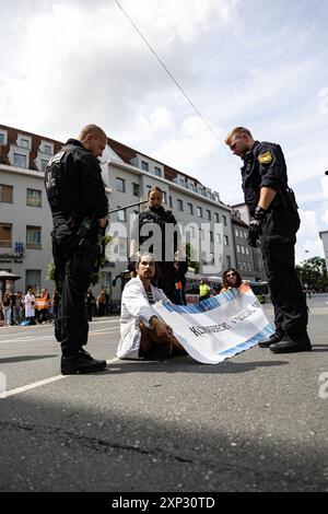 Augsburg, Deutschland. August 2024. Letzte Generation ungehorsame Versammlung am 3. August 2024 in Augsburg. Sie protestieren unter dem Motto " Öl tötet " wie die internationale Kampagne des A22-Netzes, das derzeit Flughäfen blockiert, die einen Vertrag über die Nichtverbreitung fossiler Brennstoffe fordern. (Foto: Alexander Pohl/SIPA USA) Credit: SIPA USA/Alamy Live News Stockfoto