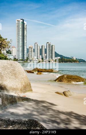 Ein Blick auf den Tanjing Tokong Strand in Penang, Malaysia, mit hohen, modernen Wolkenkratzern, Teil einer Stadtlandschaft im Hintergrund. Stockfoto