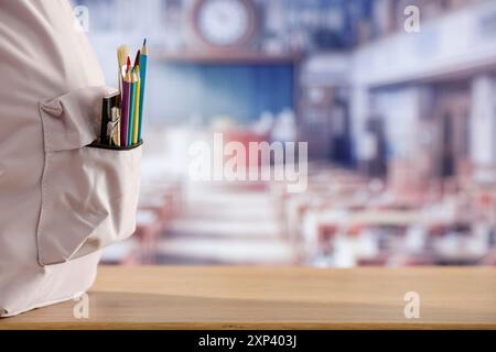 Schulsachen und Rucksack auf der Schulbank im Klassenzimmer. Verschwommener Hintergrund der Tafel an Wand und Fenster mit Sonnenlicht. Stockfoto