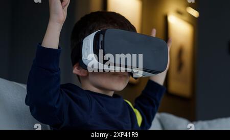 Ein kleiner Junge, der die virtuelle Realität mit einem VR-Headset erkundet. Die Faszination und Interaktivität moderner Technik für Kinder. Stockfoto