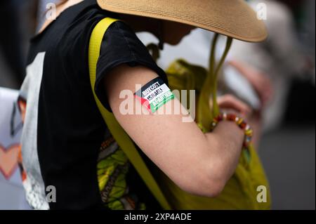 London, UK, 3. August 2024. Eine Demonstrantin, die einen Pro-Palästina-Aufkleber am Arm trägt. Pro-palästinensische Demonstranten marschieren in London, um Palästina zu unterstützen, und fordern von der britischen Regierung, ein „wechselseitiges Waffenembargo gegen Israel“ zu verhängen. Quelle: David Tramontan / Alamy Live News Stockfoto