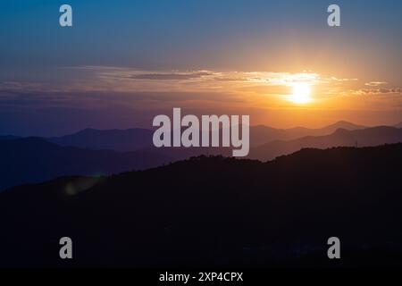 Wunderschöner Blick auf die untergehende Sonne über den mehrschichtigen Hügeln im hohen Norden der Toskana, Italien. Stockfoto