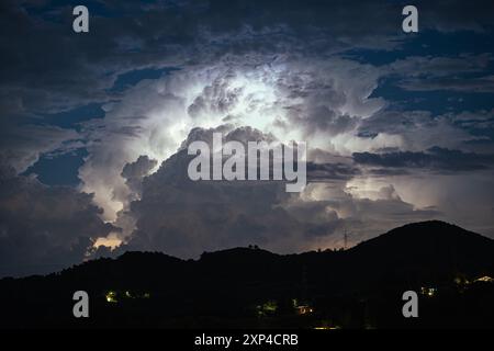 Eine Gewitterwolke über der nördlichen Toskana, Italien, wird nachts von innen durch Blitze beleuchtet Stockfoto