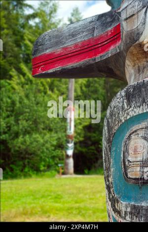 Detail eines geschnitzten Totems im Saxman Totem Park in der Nähe von Ketchikan, das den Schnabel eines Raben zeigt, der in Zedernholz geschnitzt und hell bemalt ist. Stockfoto