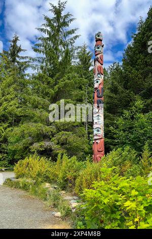 Im Saxman Totem Park in der Nähe von Ketchikan, Alaska, steht ein Totempfahl zwischen Bäumen. Es wird angenommen, dass Totems Abstammung und Erbe zurückverfolgen. Stockfoto