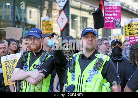 Manchester, Großbritannien. August 2024. Stellen Sie sich dem Rassismus entgegen und protestieren Sie gegen einwanderungsfeindliche Demonstranten, die die Ereignisse in Southport, wo drei Kinder ermordet wurden, auf die Straße gegangen sind, um ihre Botschaft zu verbreiten. In der Stadt gibt es eine starke Polizeipräsenz, die die Bewegung des Aufstandes gegen Rassismus-Proteste einschränkt. Manchester, Großbritannien. Stockfoto