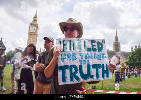 London, Großbritannien. August 2024. Ein Demonstrant hält während der Demonstration auf dem Parlamentsplatz ein Plakat mit dem Titel "Haft wegen Wahrheitssage". Die Demonstranten versammelten sich in Solidarität mit 21 Just Stop Ölaktivisten, die derzeit wegen verschiedener Klimaproteste im Gefängnis sind. Quelle: SOPA Images Limited/Alamy Live News Stockfoto