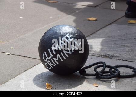 London, Großbritannien. August 2024. Während der Demonstration auf dem Parlamentsplatz wird ein "Klima-krimineller" Ball und eine Kette gesehen. Die Demonstranten versammelten sich in Solidarität mit 21 Just Stop Ölaktivisten, die derzeit wegen verschiedener Klimaproteste im Gefängnis sind. Quelle: SOPA Images Limited/Alamy Live News Stockfoto