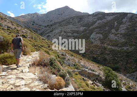 Ein junger Mann wandert auf dem Berg Zas in Richtung der Höhle von Za auf der Insel Naxos, Kykladen, Griechenland Stockfoto