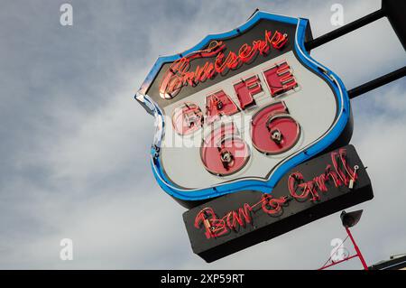 Vintage Neonschild für Cruiser's Cafe 66 Bar und Grill, teilweise bewölkter Himmel. Stockfoto