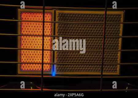 Nahaufnahme einer glühenden elektrischen Heizung mit Metallgitter, warmen und kühlen Elementen. Stockfoto