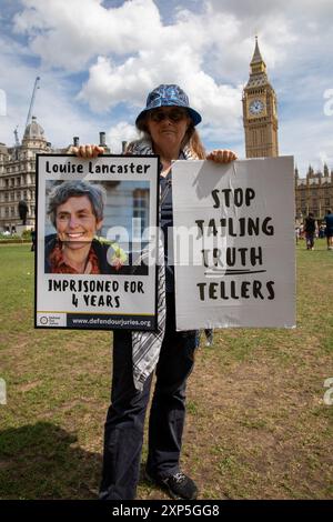 London, Großbritannien. August 2024. Ein Demonstrator der Extinction Rebellion hält während der Demonstration Plakate. Mitglieder der Extinction Rebellion veranstalteten eine Kundgebung auf dem Parliament Square in Central London. Ihr Ziel ist es, Mitprotestierende zu unterstützen, die für ihren legitimen Protest verhaftet und inhaftiert wurden. Quelle: SOPA Images Limited/Alamy Live News Stockfoto