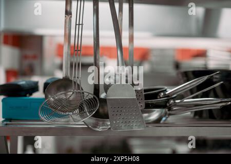 Küchenutensilien, Pfannen und Töpfe in einer professionellen Küche. Industrielle Hardware in einer Restaurantküche. Keine Personen. Stockfoto