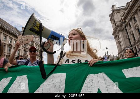 London, Großbritannien. August 2024. Ein Demonstrant schreit Slogans durch ein Megaphon, während er während der Demonstration ein Banner hält. Mitglieder der Extinction Rebellion veranstalteten eine Kundgebung auf dem Parliament Square in Central London. Ihr Ziel ist es, Mitprotestierende zu unterstützen, die für ihren legitimen Protest verhaftet und inhaftiert wurden. (Foto: James Willoughby/SOPA Images/SIPA USA) Credit: SIPA USA/Alamy Live News Stockfoto