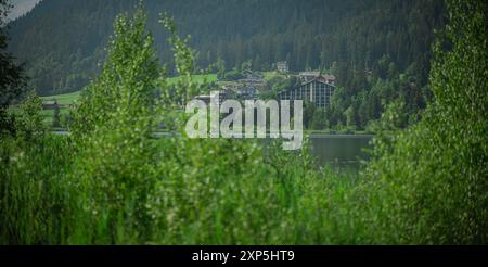 Eines der Hotels am Weisensee in österreich, sichtbares Hotel und typische Dorfhäuser am Ufer des malerischen Alpensees. Eines von österreichs Top-Destinat Stockfoto