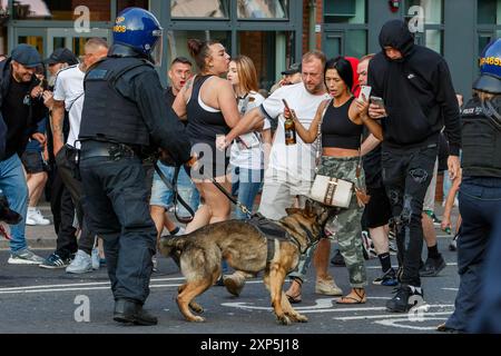 Bristol, Großbritannien. August 2024. Die Polizei wird im Bild dargestellt, als sie während eines genug-ist-genug-Protestes in der Nähe des Castle Park im Zentrum von Bristol von rechtsextremen Aktivisten konfrontiert wird. Bei ähnlichen Protesten in mehreren englischen Städten und Städten ist nach einem Massenerstech, bei dem drei junge Mädchen getötet wurden, Gewalt ausgebrochen. Die Polizei in Bristol hat zusätzliche Befugnisse erhalten, um Menschen aufzuhalten, zu durchsuchen und zu zerstreuen, um zu verhindern, dass Probleme zwischen der rechtsextremen Gruppe und den antirassistischen Demonstranten entstehen, die einen Gegenprotest organisiert haben. Quelle: Lynchpics/Alamy Live News Stockfoto