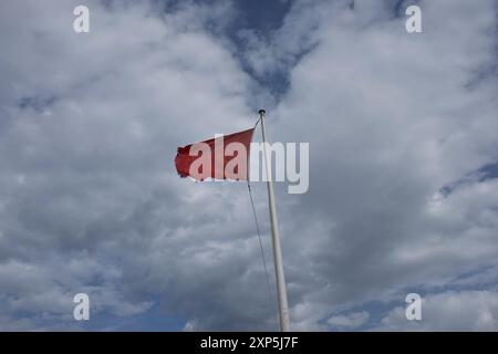 Eine rote Flagge signalisiert die Gefahr, die am Strand von Famara auf Lanzarote auf den Kanarischen Inseln flattert. Stockfoto