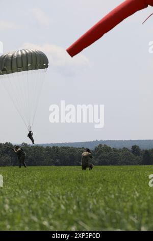 Austin Berner, der der 982nd Combat Camera Company (Airborne) zugeteilt wurde, fotografiert die Landung zweier Fallschirmjäger auf Glen Rock Dropzone, Exeter, Rhode Island während des Leapfests 2024. Das Leapfest ist das größte und längste internationale Static Line Fallschirmtraining und Wettkampf, das vom 56. Truppenkommando der Rhode Island Army National Guard veranstaltet wird, um ein hochrangiges technisches Training zu fördern und den Einsatz von Corps innerhalb der International Airborne Community zu fördern. (Foto der Armee-Reserve von Major Yau-Liong Tsai) Stockfoto