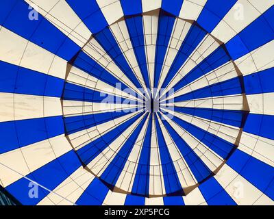 Tauchen Sie ein in eine Welt voller Wunder. Dieses Foto fängt die ruhige Schönheit eines Heißluftballons ein, gefüllt mit warmer Luft und bereit für den Flug. Stockfoto