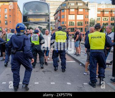 Bristol, Großbritannien. August 2024. Die Polizei wird im Bild dargestellt, als sie während eines genug-ist-genug-Protestes in der Nähe des Castle Park im Zentrum von Bristol von rechtsextremen Aktivisten konfrontiert wird. Bei ähnlichen Protesten in mehreren englischen Städten und Städten ist nach einem Massenerstech, bei dem drei junge Mädchen getötet wurden, Gewalt ausgebrochen. Die Polizei in Bristol hat zusätzliche Befugnisse erhalten, um Menschen aufzuhalten, zu durchsuchen und zu zerstreuen, um zu verhindern, dass Probleme zwischen der rechtsextremen Gruppe und den antirassistischen Demonstranten entstehen, die einen Gegenprotest organisiert haben. Quelle: Lynchpics/Alamy Live News Stockfoto