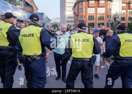 Bristol, Großbritannien. August 2024. Die Polizei wird im Bild dargestellt, als sie während eines genug-ist-genug-Protestes in der Nähe des Castle Park im Zentrum von Bristol von rechtsextremen Aktivisten konfrontiert wird. Bei ähnlichen Protesten in mehreren englischen Städten und Städten ist nach einem Massenerstech, bei dem drei junge Mädchen getötet wurden, Gewalt ausgebrochen. Die Polizei in Bristol hat zusätzliche Befugnisse erhalten, um Menschen aufzuhalten, zu durchsuchen und zu zerstreuen, um zu verhindern, dass Probleme zwischen der rechtsextremen Gruppe und den antirassistischen Demonstranten entstehen, die einen Gegenprotest organisiert haben. Quelle: Lynchpics/Alamy Live News Stockfoto