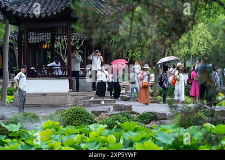 Suzhou, China - 11. Juni 2024 : Touristen erkunden den bescheidenen Administratorengarten in Suzhou, China, inmitten üppiger Grünflächen und traditioneller Architektur Stockfoto