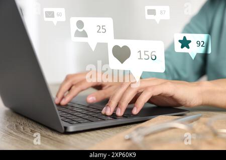 Content-Manager. Frau, die drinnen an einem Laptop arbeitet, Nahaufnahme. Gefällt mir, Follower, E-Mails, Nachrichten und Hinzufügen zu Favoritenbenachrichtigungen über das Gerät Stockfoto