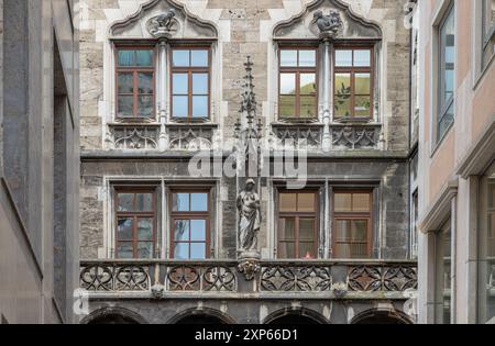 München, Deutschland - 21. Dezember 2023 - Sandsteingebäude mit vielen Fenstern ist mit gotischen Statuen dekoriert. Außenarchitektur von Fam Stockfoto