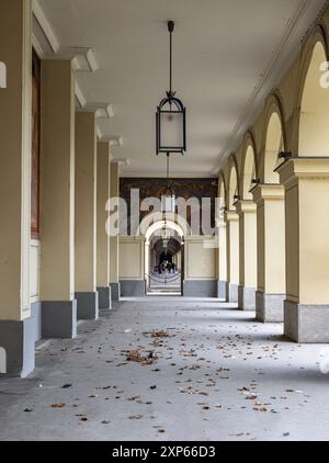 München, Deutschland - 21. Dezember 2023 - perspektivischer Blick auf den langen Korridor mit antiker Laterne, die von der Decke hängt, und wunderschönen Säulen im Hofgartenark Stockfoto