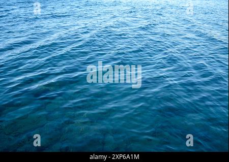 Der Blick durch einen Aussichtshafen zwischen Boden, Boden und Oberfläche des luxuriösen Swimmingpools und blauem Wasser Stockfoto