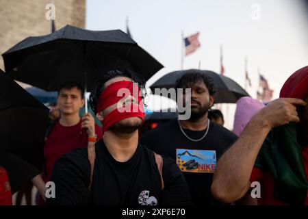 Washington DC, USA. August 2024. Ein Teilnehmer fesselt ein rotes Tuch auf seinen Mund und seine Augen, während er am 3. August 2024 an einer Mahnwache bei Kerzenlicht in der National Mall in Washington DC, USA teilnimmt, um die Anti-Diskriminatory Students Movement in Bangladesch zu unterstützen. In der Mahnwache verurteilten die Teilnehmer die Regierung für den Mord an unschuldigen und minderjährigen Studenten. Sie fordern auch, den derzeitigen Premierminister Scheich Hasina, der seit 2009 an der Macht ist, zurückzutreten. Aber später begannen Proteste mit Blutvergießen, mehr als 250 Menschen wurden getötet. (Aashish Kiphayet) C Credit: Aashish Kiphayet/Alamy Live News Stockfoto