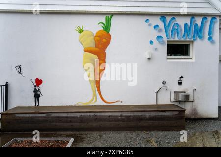 Bergen, Norwegen - 30. April 2024: Ein lebendiges Wandbild, das eine Karotte und Pastinaken an der Wand eines Gebäudes zeigt. Stockfoto