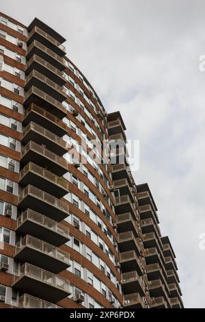 Hausfassade aus rotem Backstein mit Balkonreihen in New York, NY, USA. Stockfoto