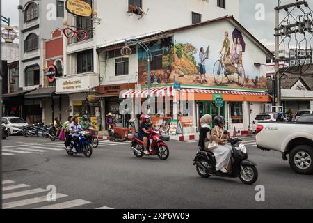 Blick auf die Innenstadt von Phuket in Thailand mit Motorrädern und Autos auf der Straße. Eine geschäftige Straße mit Restaurants und Geschäften. Reiseziel. Straßenfoto. Stockfoto