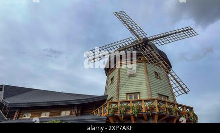 Riga, Lettland - 14 07 2024: Eine große Windmühle befindet sich auf dem Dach eines Gebäudes, dem Lido Entertainment Center. Stockfoto